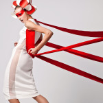 model in white with red ribbon